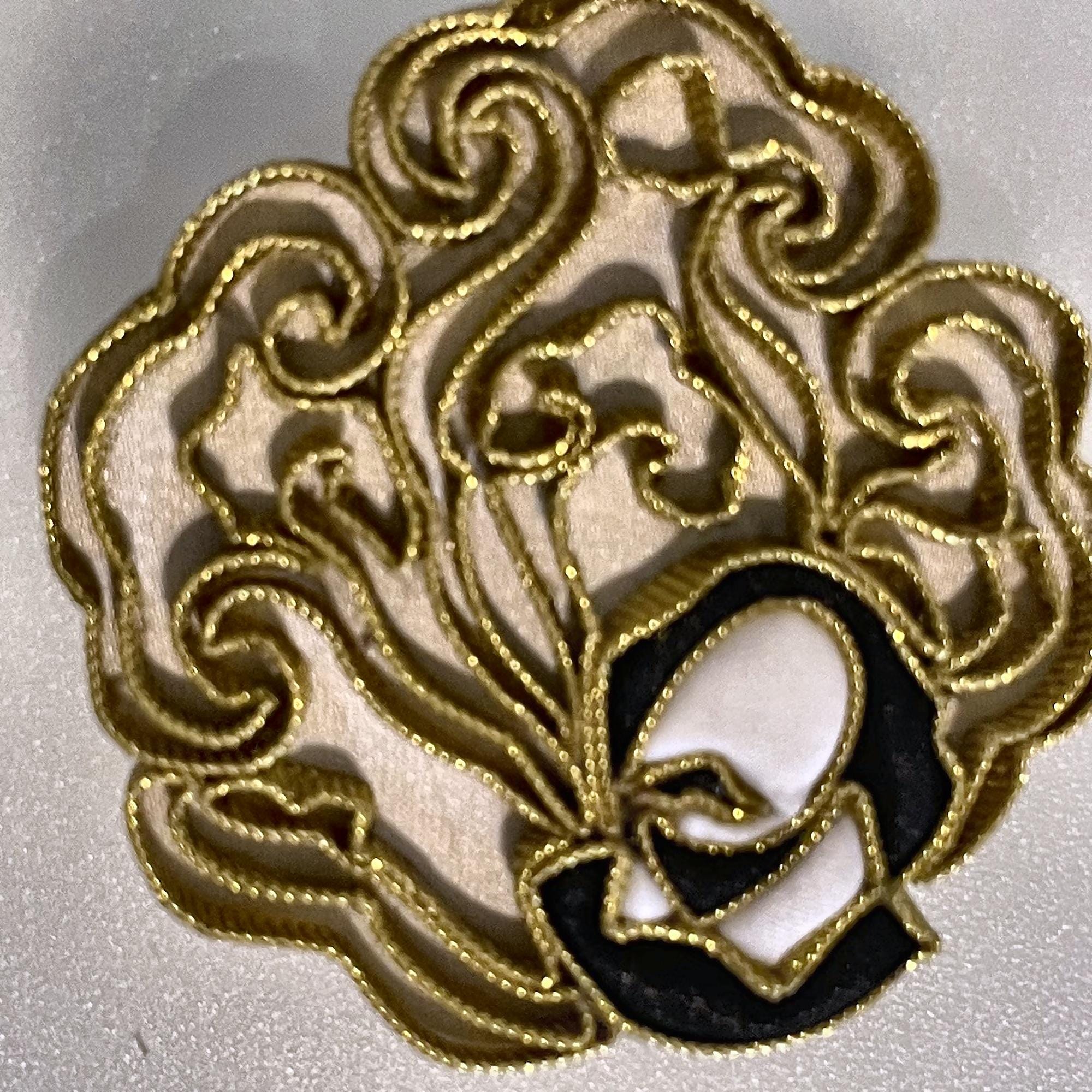 Close-up of the couched gold thread and silk cord of the lucky cloud brooch
