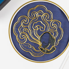 Close-up of the hand-embroidered gold cloud roundel with the Shakespeare portrait