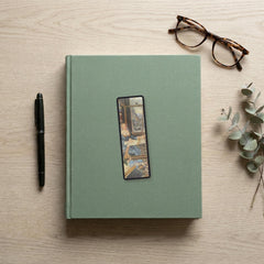 Penelope at Her Loom Odyssey bookmark flat lay on a desk with a book, pen and reading glasses