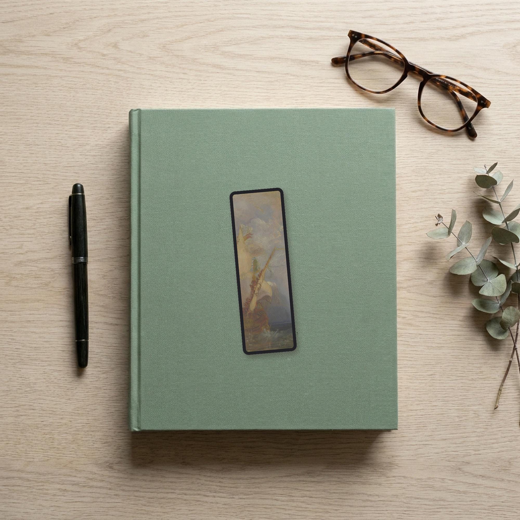 Escape at Dawn Odyssey bookmark flat lay on a desk with a book, pen and reading glasses