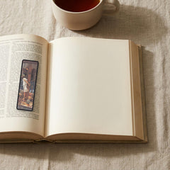 Bound to the Mast Odyssey bookmark lying on an open book, the page text visible through the sheer organza