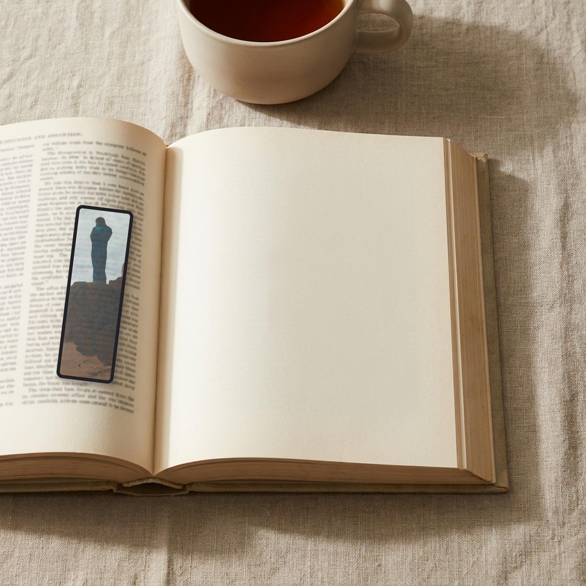 The Wanderer Odyssey bookmark lying on an open book, the page text visible through the sheer organza
