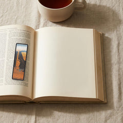 The Siren Vase Odyssey bookmark lying on an open book, the page text visible through the sheer organza
